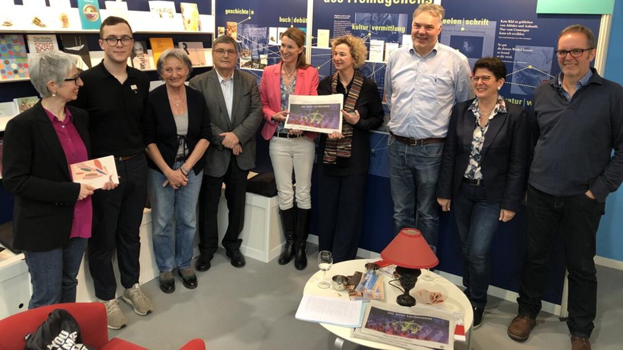 Elisabeth Stöckler (Kulturstiftung Liechtenstein), Florin Konrad (Praktikant in der Botschaft Berlin), Silvia Ruppen (Graphikerin), Roland Marxer (Präsident der Kulturstiftung Liechtenstein), Isabel Gottschald-Frommelt (Botschafterin von Liechtenstein in Berlin), Katrin Bastian (Wiss. Referentin der Botschafterin in Berlin), Stefan Sprenger (Autor), Brigitte Weber (Kulturstiftung Liechtenstein), Roman Banzer (Autor und Musiker)